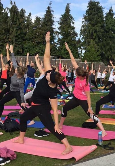 Large group doing outdoor yoga classes image 2
