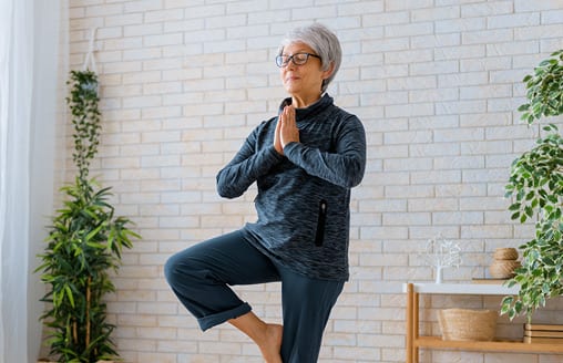 Elderly woman practising yoga pose